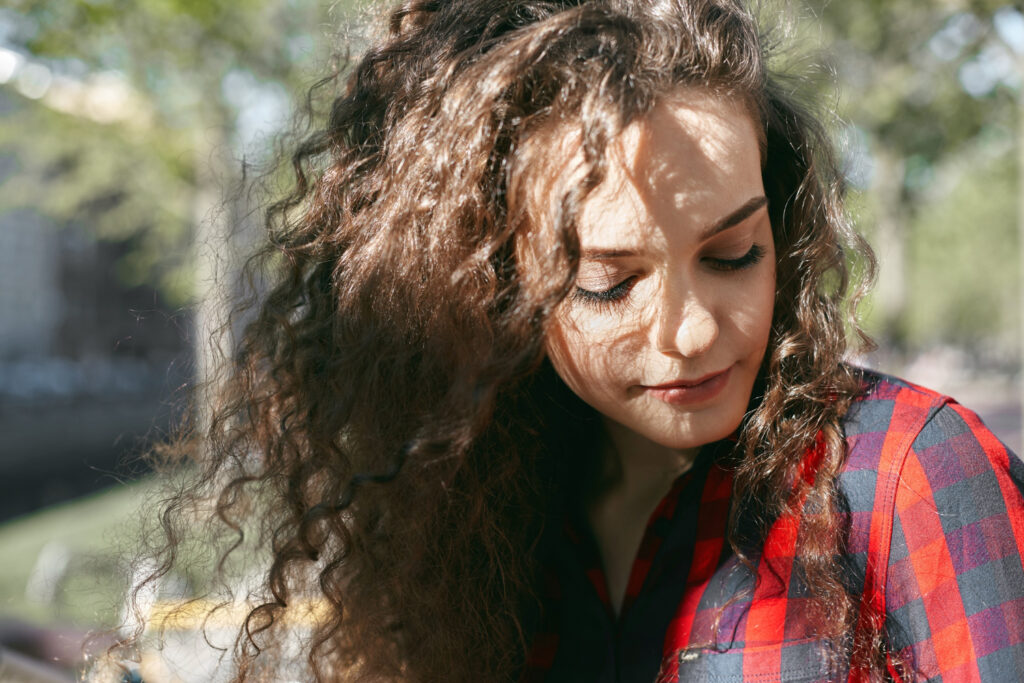 Person embracing natural curly and frizz-free hair.