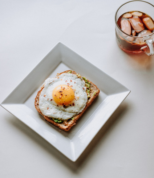 A plate full of a nutritious hot breakfast eggs omelet with brown bread.