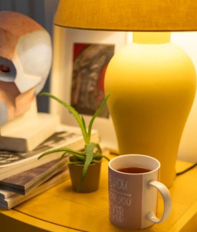 A cup of chamomile tea on a wooden nightstand.