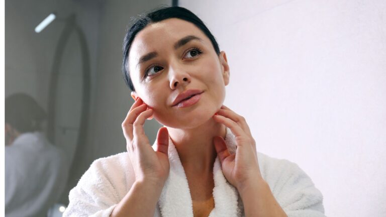 A woman applying a hydrating serum in her winter skincare routine.