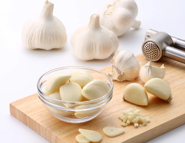 Fresh garlic cloves on a wooden board.